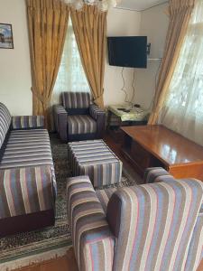 a living room with couches and a table and a television at Bella Casa villa in Nuwara Eliya