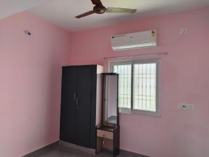 Habitación con armario negro y ventana en Senthil GRS HomeStay, en Tiruvannāmalai