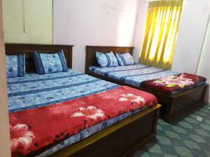 two beds sitting next to each other in a room at Bella Casa villa in Nuwara Eliya