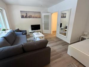 a living room with a couch and a tv at Frisch renoviertes Appartement in Mönchengladbach