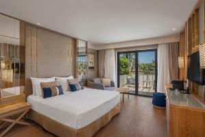 a bedroom with a large bed and a living room at Ela Excellence Resort Belek in Belek