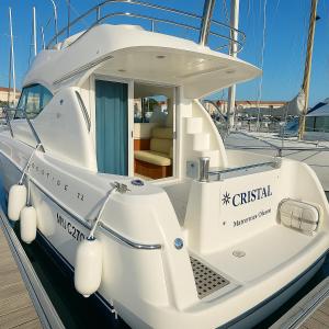 a white boat is docked at a dock at Vedette Cristal Prestige 32 in Les Sables-dʼOlonne