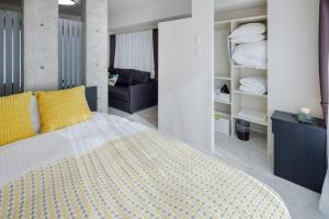 une chambre avec un grand lit avec des oreillers jaunes dans l'établissement LAN Sapporo Nijo Market, à Sapporo