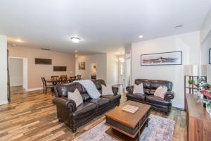 a living room with leather furniture and a table at Lakeside Villa Retreat 5-Bedroom Oasis with 6 TVs 3-Acres of Waterfront Fishing & Canoe Adventures in Harlem