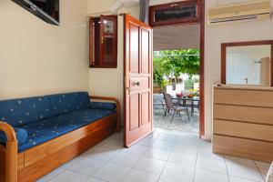 a living room with a blue couch and a door at Ballas Apartments in Agia Effimia