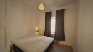a small bedroom with a bed and a window at Home Inn NBG6 in Stockholm