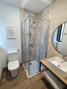 a bathroom with a shower and a toilet and a sink at Hotel Casa dos Gardas in Samos