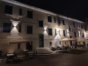 a building with tables and umbrellas outside at night at Hotel Casa dos Gardas in Samos +11 photos