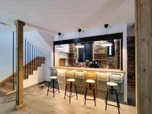a bar with stools in a room with stairs at Hotel Casa dos Gardas in Samos