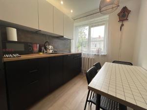 una cocina con armarios negros y una mesa con sillas en Kauguri Breeze, en Jūrmala 18 fotos más