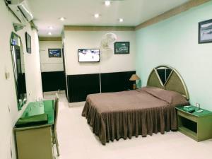 a bedroom with a bed and a flat screen tv at Hotel City View Peshawar in Peshawar