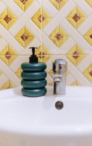 a stack of green disks sitting on top of a sink at Ngicha 1BDR APT, Dar es Salaam - Boko in Dar es Salaam