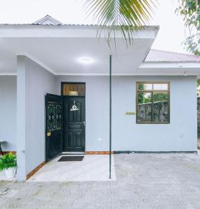 a white house with a black door at Ngicha 1BDR APT, Dar es Salaam - Boko in Dar es Salaam