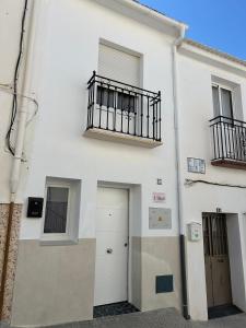 a white building with a balcony and a door at La buganvilla dell Torcal in Villanueva de la Concepción