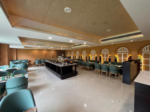 a dining room with chairs and a bar in it at Anandi Bhawan by Paandora in Chhatikara