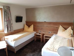 una camera d'albergo con due letti e un lavandino di Haus Deutinger a Piesendorf