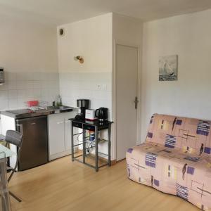 a room with a kitchen and a couch and a table at Belle étape Honfleuraise in Honfleur