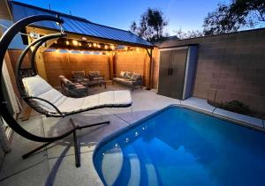 a swimming pool with a chair and a couch next to a house at Family Friendly Contemporary House with Pool in Las Vegas