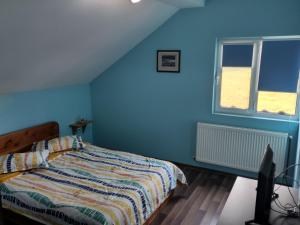 Un dormitorio azul con una cama y una ventana. en Casa Maria Alexandra, en Berceşti
