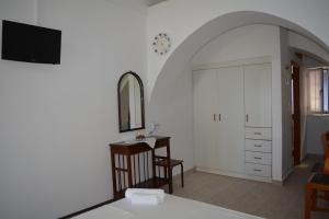 a room with a door and a table and a mirror at Volta Stonehouse Apartments in Frátsia