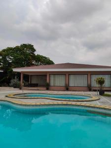 eine Gruppe von drei Pools vor einem Gebäude in der Unterkunft Poolside Cottage in Lubao