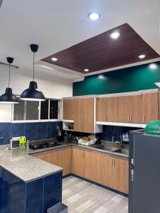 a kitchen with wooden cabinets and a blue wall at Poolside Cottage in Lubao