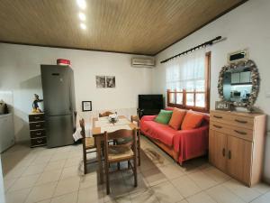 a living room with a red couch and a table at Kinira Seaside House in Koinyra