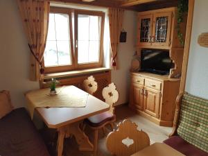 een kleine woonkamer met een tafel en een televisie bij Haus Deutinger in Piesendorf