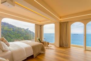 a bedroom with a large bed and large windows at AKANARA · Yangchou Paradise Resort in Dapeng