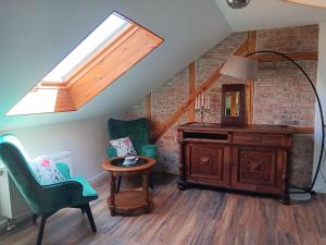 a attic room with a skylight and two chairs and a desk at Ferienwohnung Harzteufel in Blankenburg
