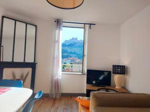 a living room with a window and a couch and a television at Nid cosy face à la Cathedrale in Saint-Flour