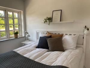 a bedroom with a bed with white sheets and pillows at Svalereden Strand Camping Apartments in Frederikshavn
