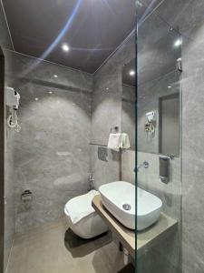 un bagno con wc, lavandino e doccia di Hotel Kalpana Palace, Mumbai a Mumbai