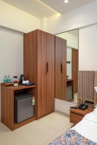 a bedroom with a large wooden cabinet and a bed at Hotel Kalpana Palace, Mumbai in Mumbai +145 photos