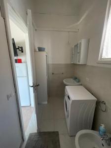 a small bathroom with a refrigerator and a sink at Casa del Mar in Porto Cesareo
