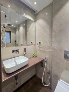 a bathroom with a sink and a shower at Hotel Kalpana Palace, Mumbai in Mumbai