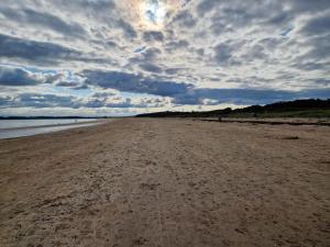 una spiaggia sabbiosa con cielo nuvoloso sullo sfondo di Banks Road a West Kirby
