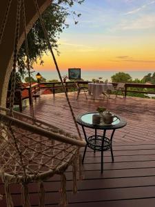 a porch with a hammock and a table with a sunset at VELAMUNDi INN Batu Ferringhi in Batu Ferringhi
