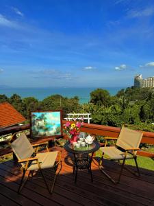 a balcony with a table and chairs and a television at VELAMUNDi INN Batu Ferringhi in Batu Ferringhi