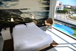 a bedroom with a bed and a view of the ocean at HI Arrifana Destination Hostel in Aljezur