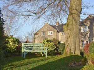a green park bench sitting in front of a house at The Old School House in Tideswell
