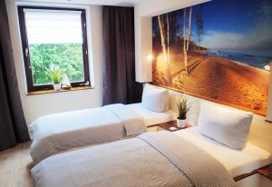 ein Hotelzimmer mit zwei Betten und einem großen Fenster in der Unterkunft Strandfeeling in Dahme