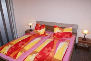 a bedroom with two beds with colorful blankets and pillows at Altstadtappartement - ABC59 in Wismar