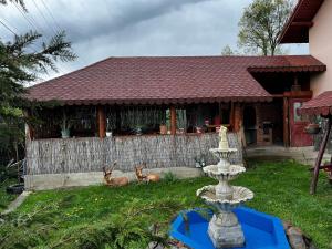 Dos ciervos sentados en el césped frente a una casa en Casa Maria Alexandra, en Berceşti