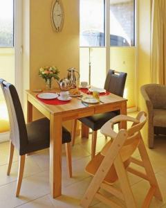Hohen WieschendorfにあるAuszeit - ABC208 an der Ostsee - nur Feriengäste!のダイニングルームテーブル(椅子付)、木製テーブル、チェアトップが備わります。