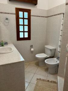 a bathroom with a toilet and a sink and a window at Rich Makuti in Watamu