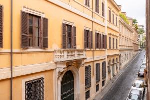 a yellow building with a balcony on a street at Maison Trevi in Rome