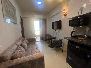 un salon avec un grand canapé et une télévision dans l'établissement Luxury Suite Princess Resort Two bedroom apartment Hurghada سويت فاخر البرنسيسه غرفتين, à Hurghada