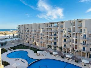 vue d'un grand immeuble d'appartements avec piscine dans l'établissement Luxury Suite Princess Resort Two bedroom apartment Hurghada سويت فاخر البرنسيسه غرفتين, à Hurghada