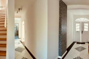 a hallway with white walls and a black and white tile floor at FEWO-Hagemeister in Schwerin - ABC571 - keine Monteure in Schwerin